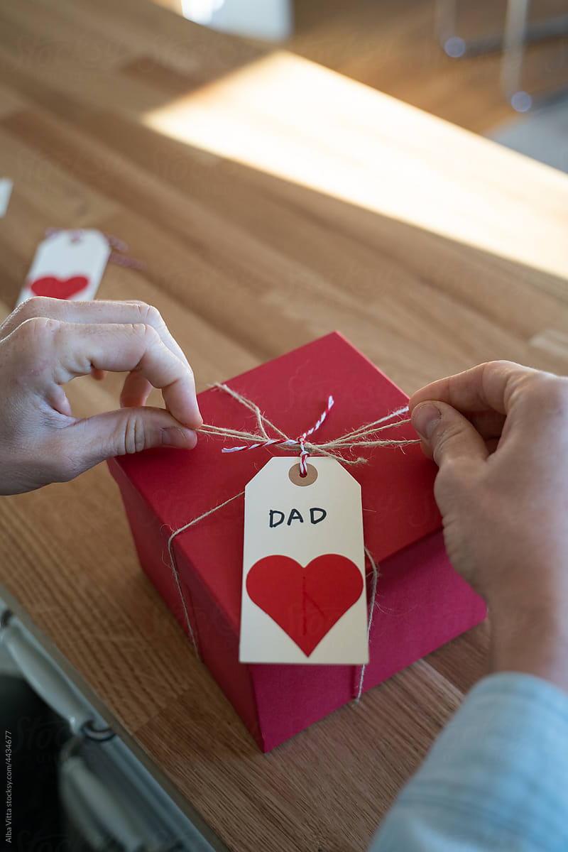Man wrapping gift for his father at home
