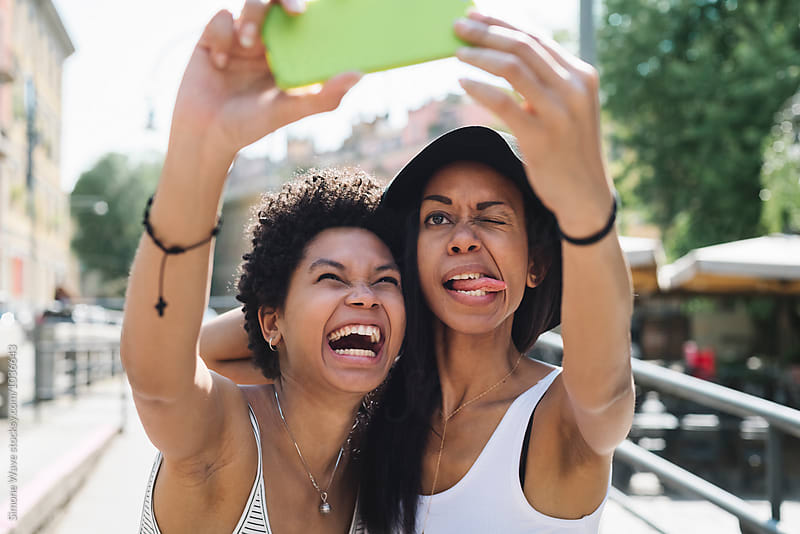Two friends taking a funny selfie outdoors