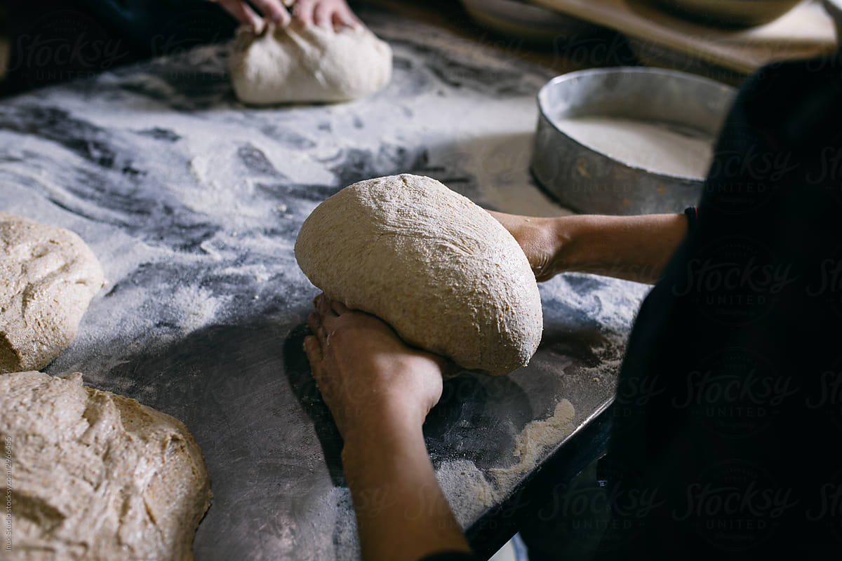 Baker working with dough in bakehouse