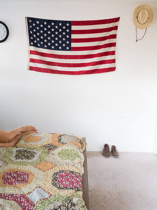 American flag and straw hat hanging on wall of bedroom