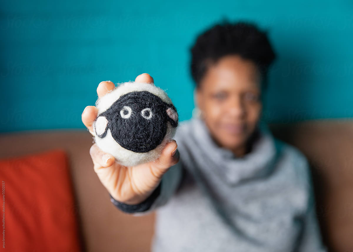 Woman holding a cute handmade sheep dryer ball