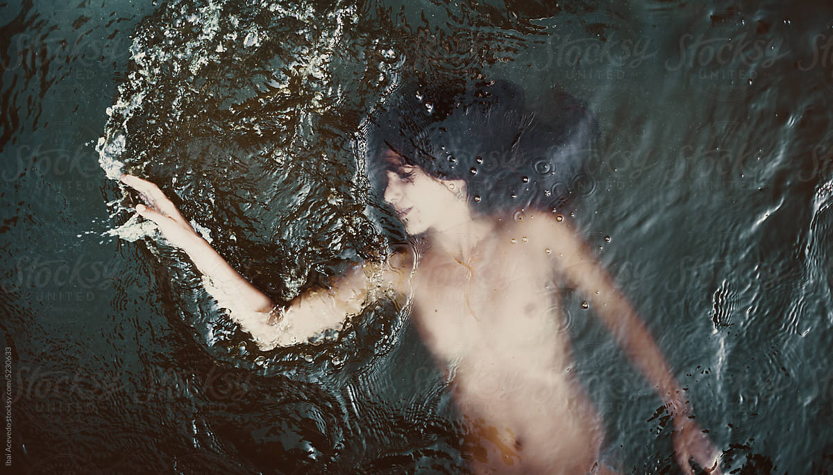 Surreal portrait of naked woman inside dark waters