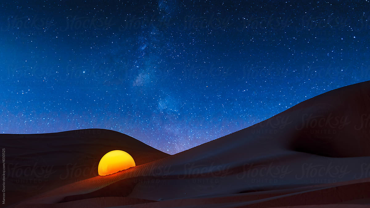 Desert landscape with a light sphere under a starry sky