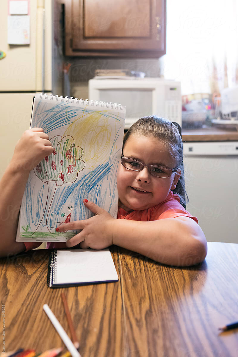 Girl Shows Off Drawing Of Child In Wheelchair