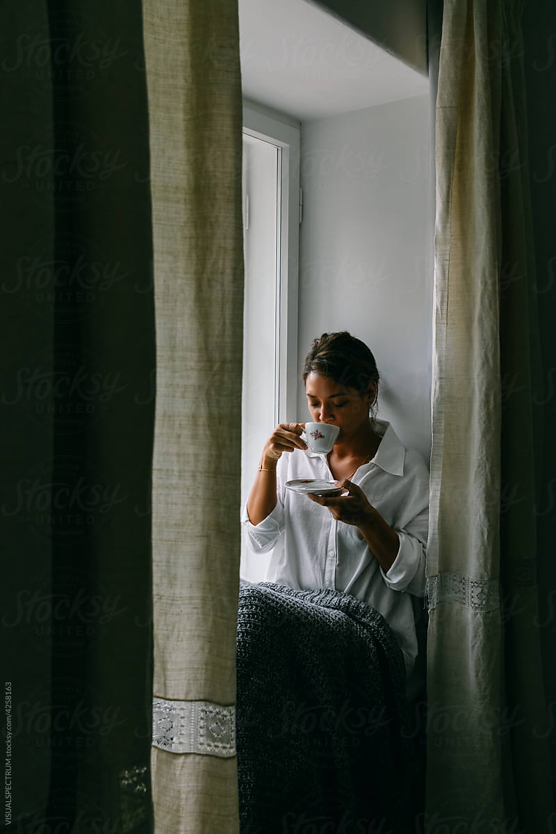Woman Drinking Tea Near Window