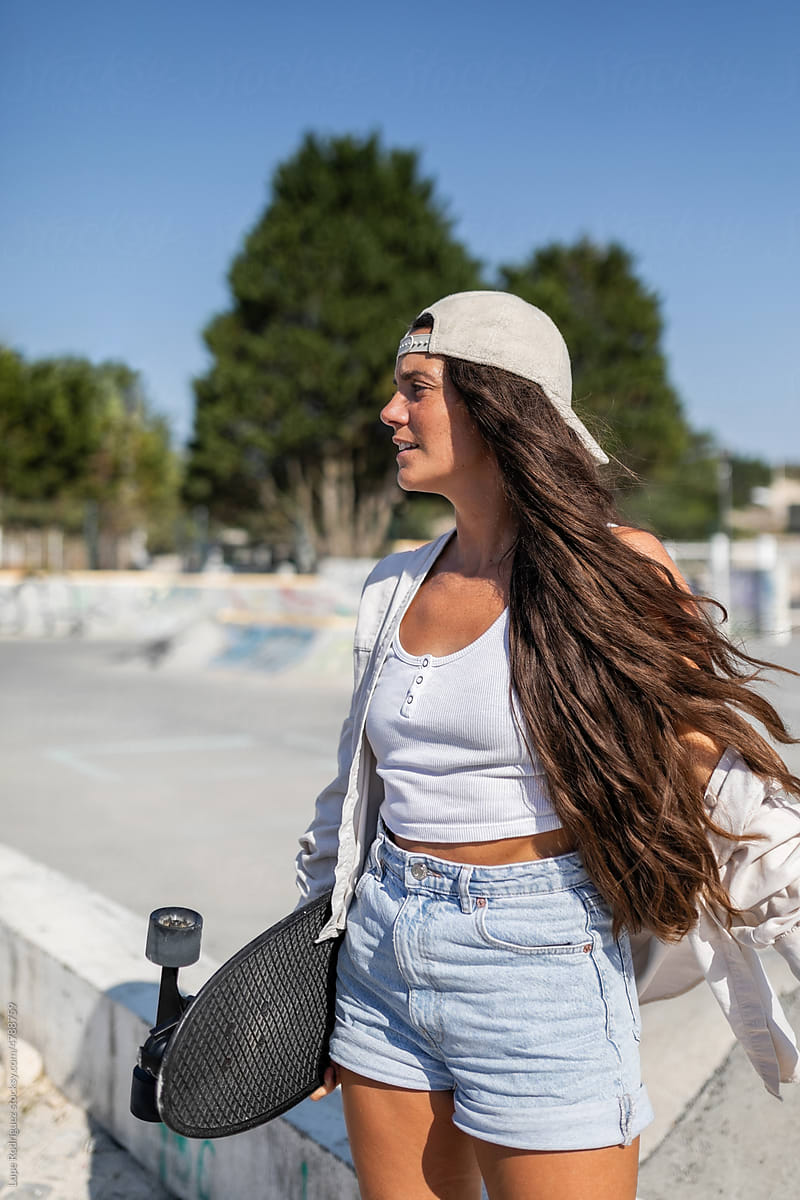 long-haired young woman in a city skate park