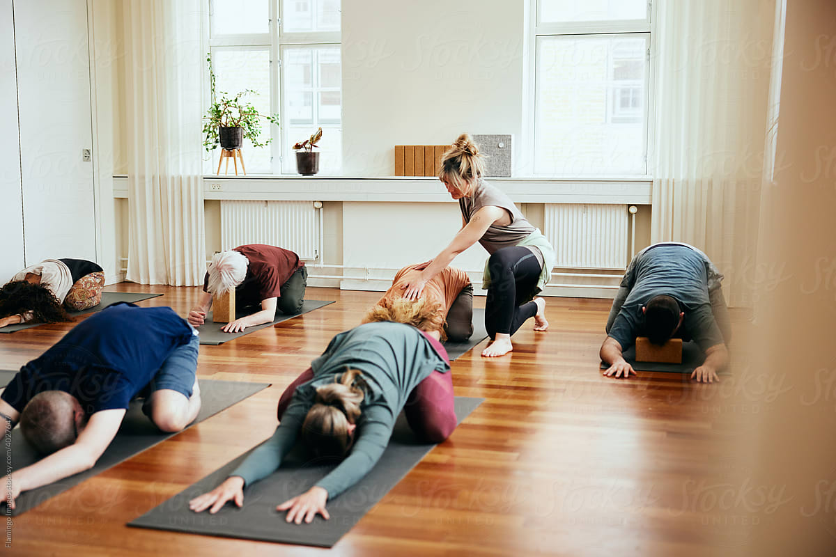 Yoga teacher helping a group