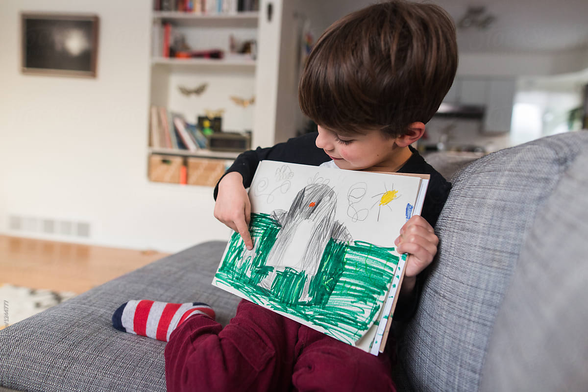 boy shows off drawing of penguin