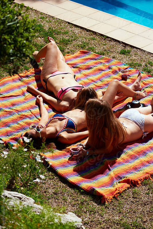 Girls sunbathing on backyard on colorful blanket