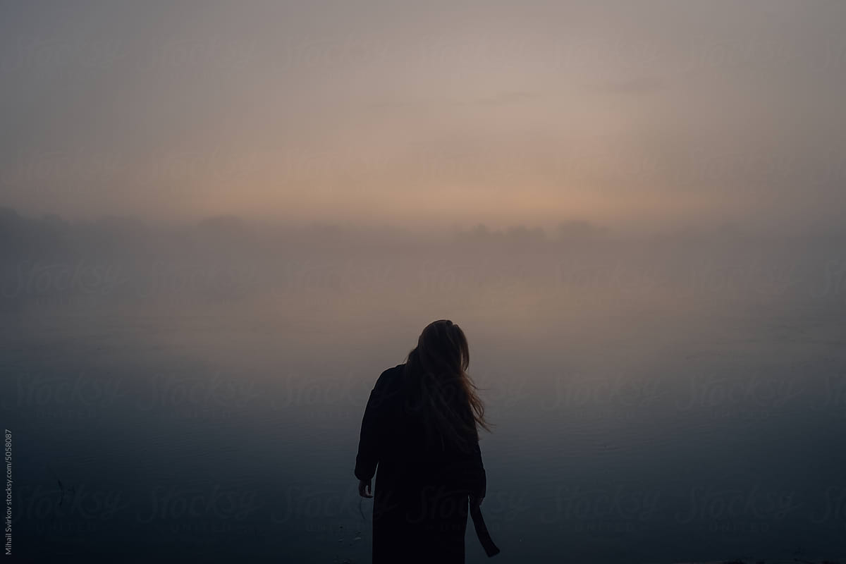 Girl on the background of a foggy river