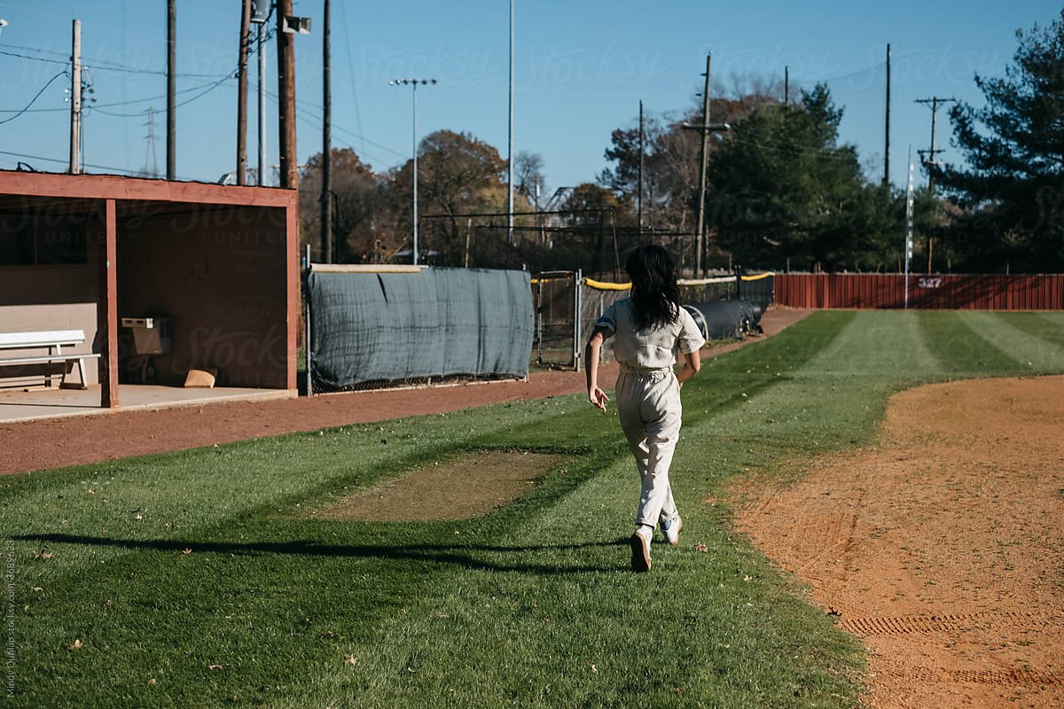Young woman running on a baseball field