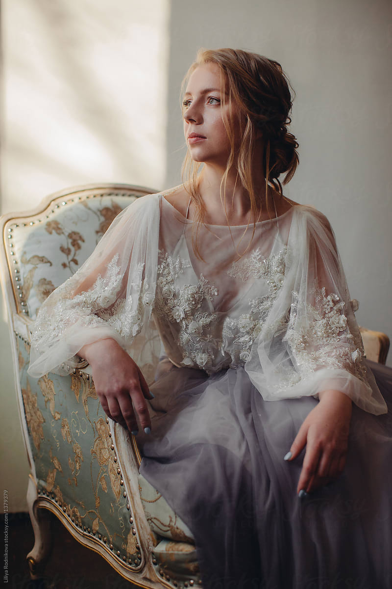 Portrait of blond woman in beautiful dress with embroidery