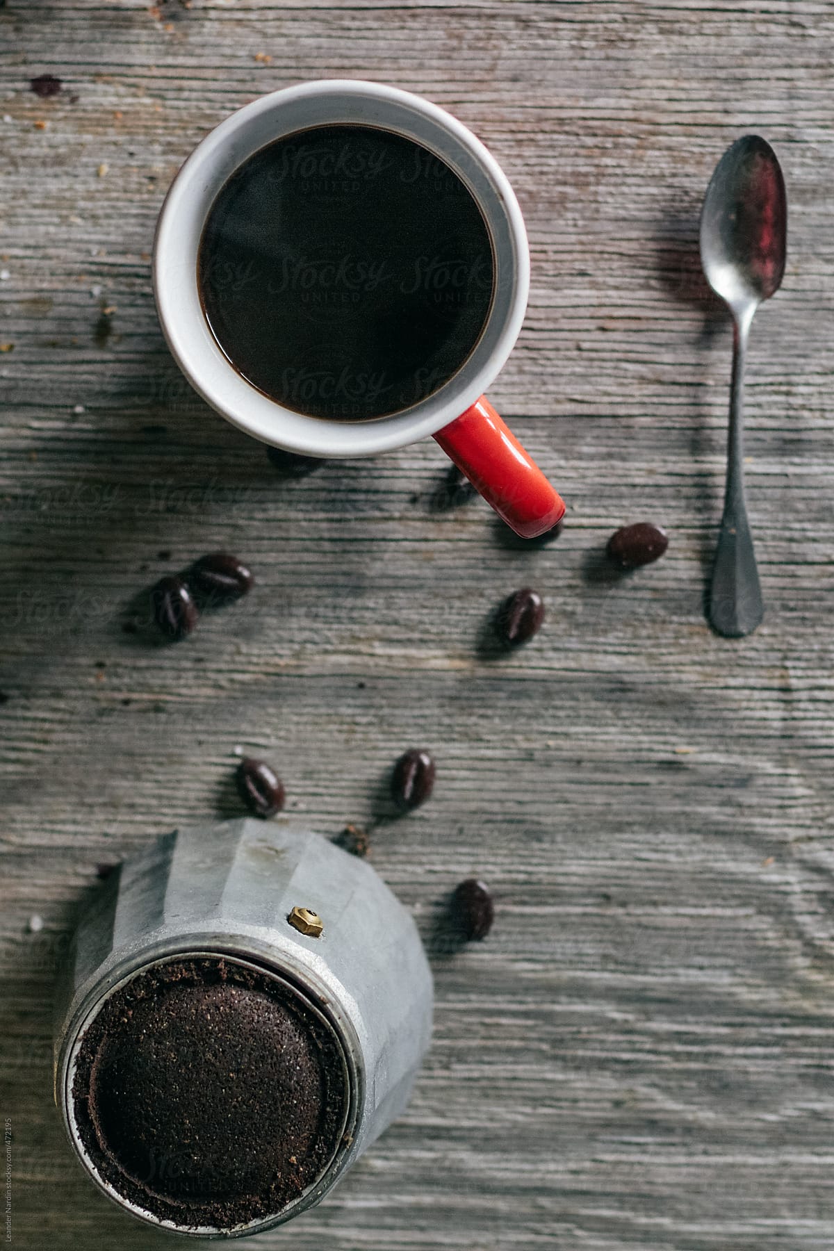 coffee in red cup, coffee beans and italian espresso maker on wooden board from above