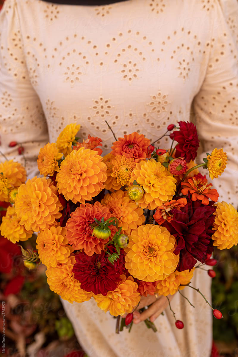 woman holding autumn bouquet of flowers