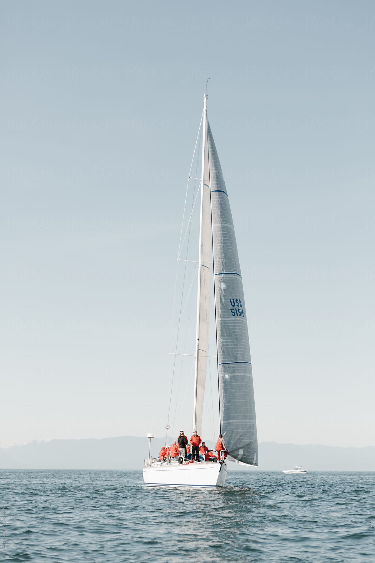 white sailboat at sea in yacht race with crew on board