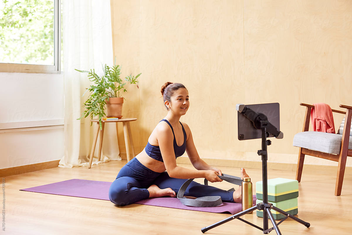 Woman stretching legs with band during yoga session