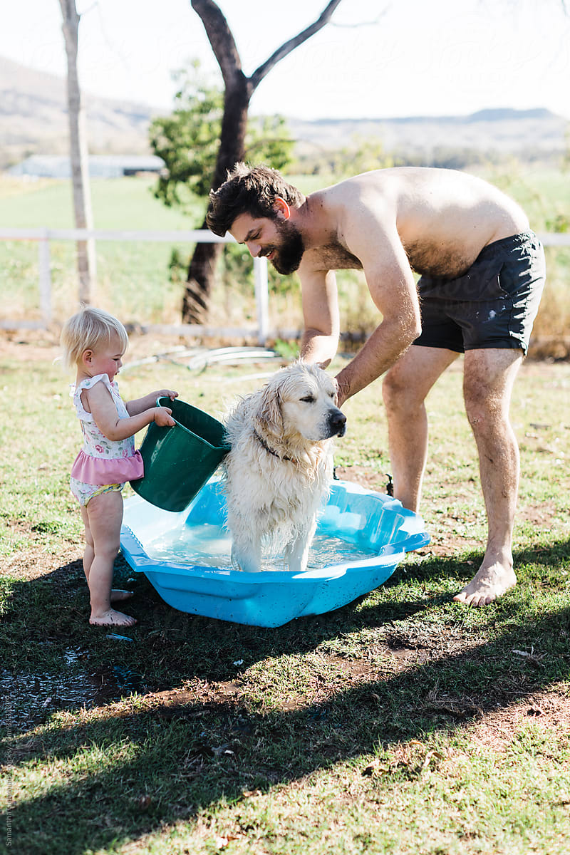 Father and daughter wash family dog