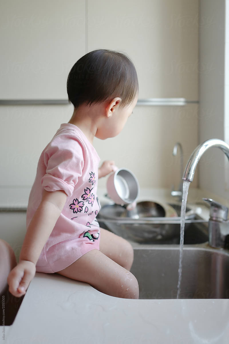 Asian babygirl playing with water