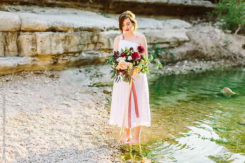 Bridal inspiration / Woman in a white dress standing by water