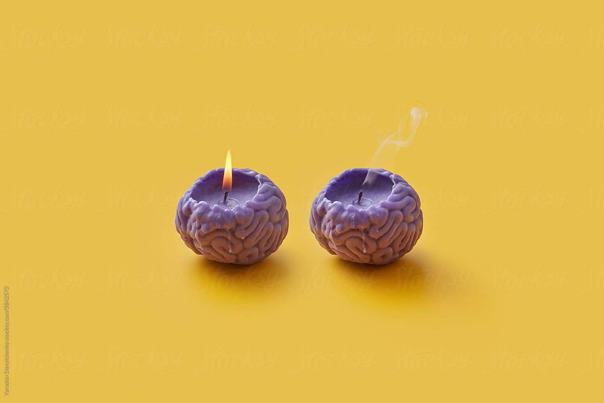 Violet candles in shape of human brain with burning and blown out ones