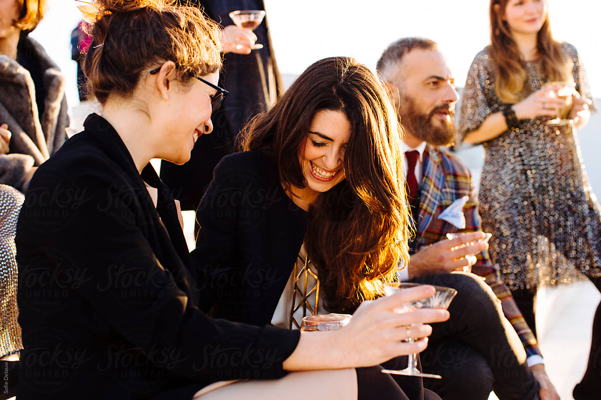 Crop happy partners with wine talking during party in sunlight