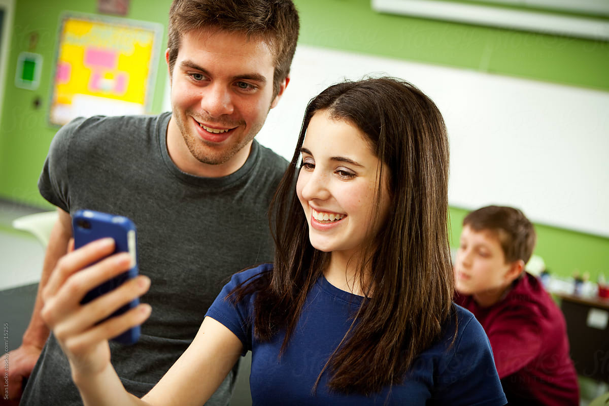 High School: Classmates Check Out Text on Cell Phone