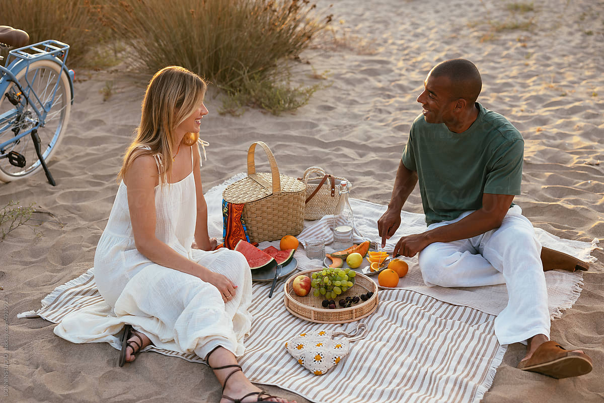Diverse man and woman chatting during picnic