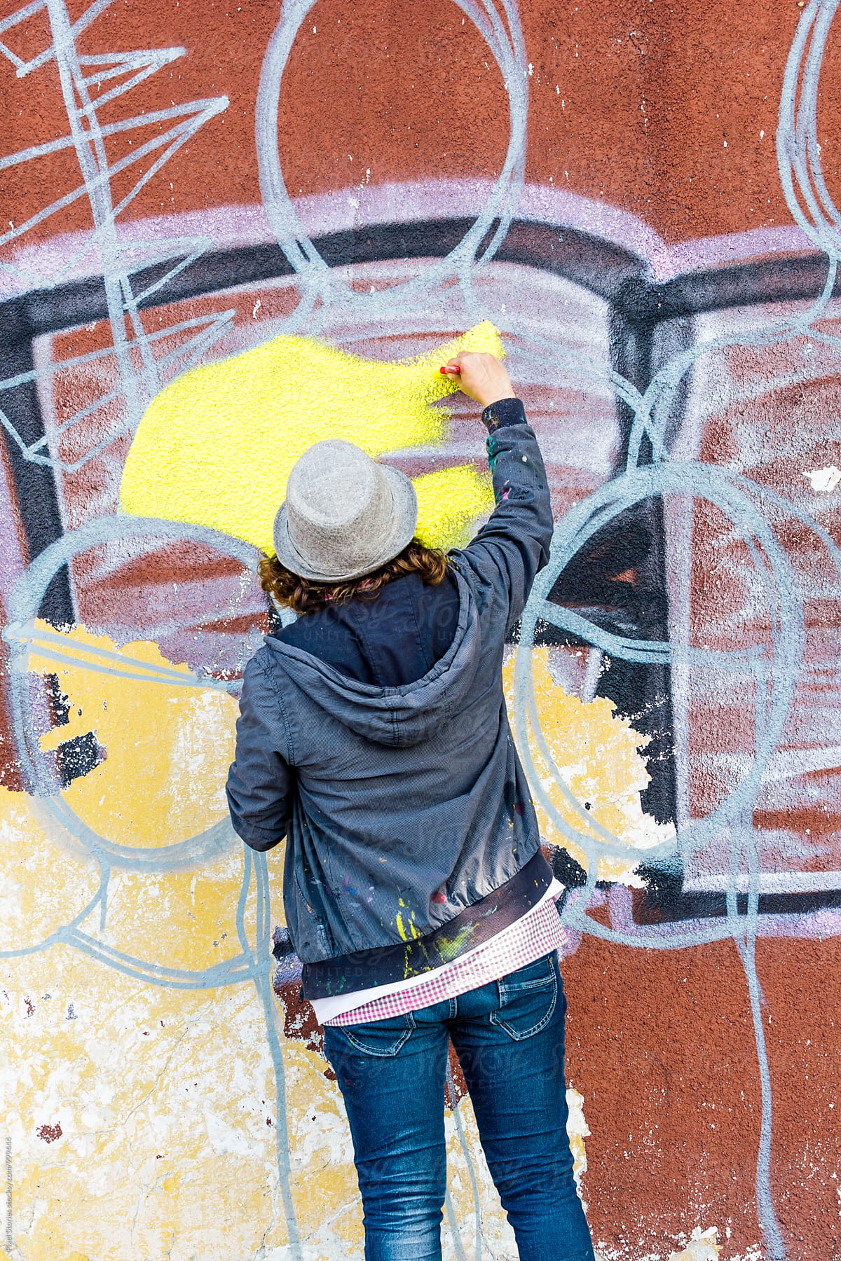 Female graffiti artist writing on wall