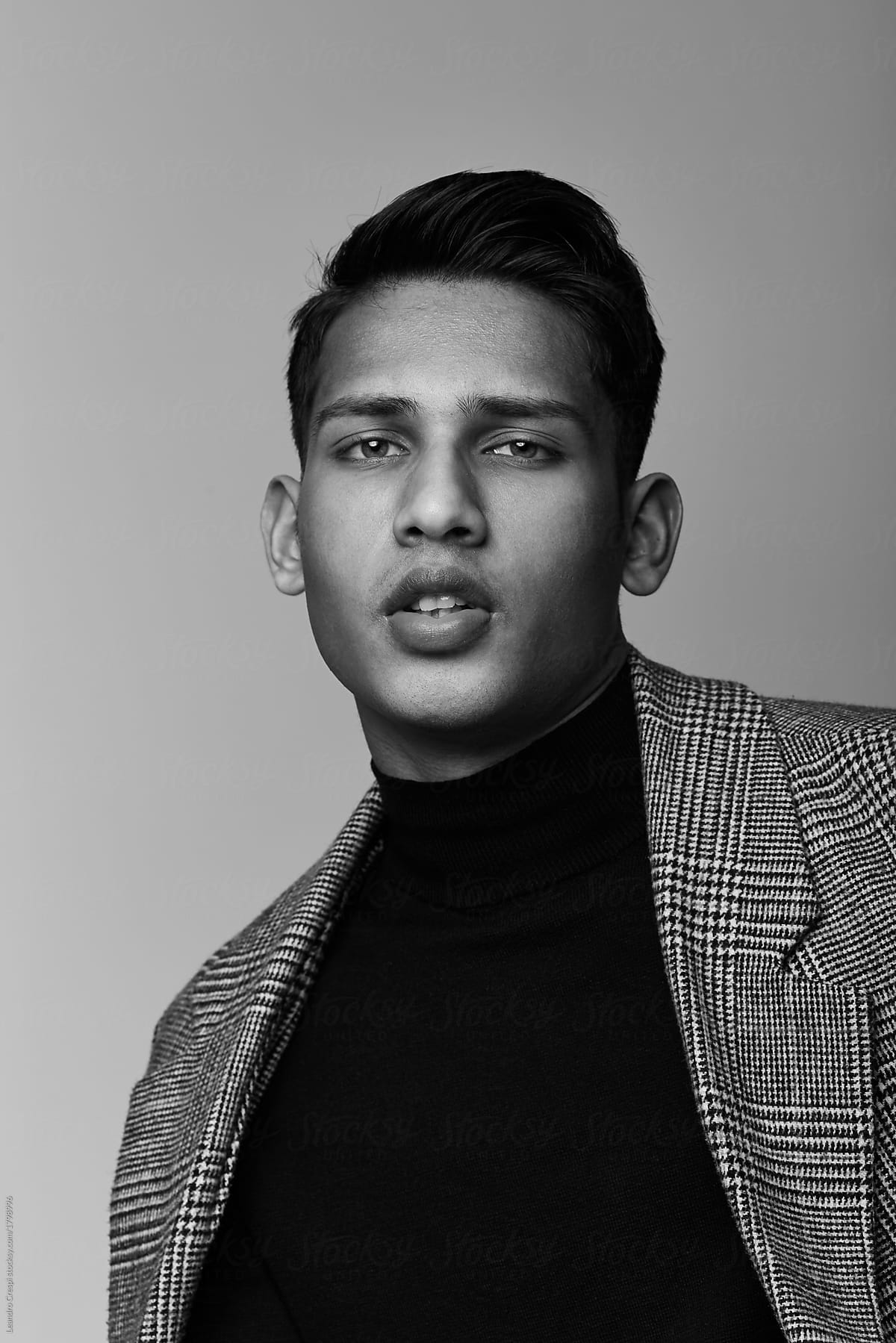 Handsome Indian guy portrait wearing turtle neck and coat on black and white