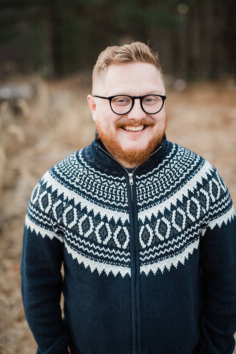 portrait of handsome redhead man wearing Christmas sweater