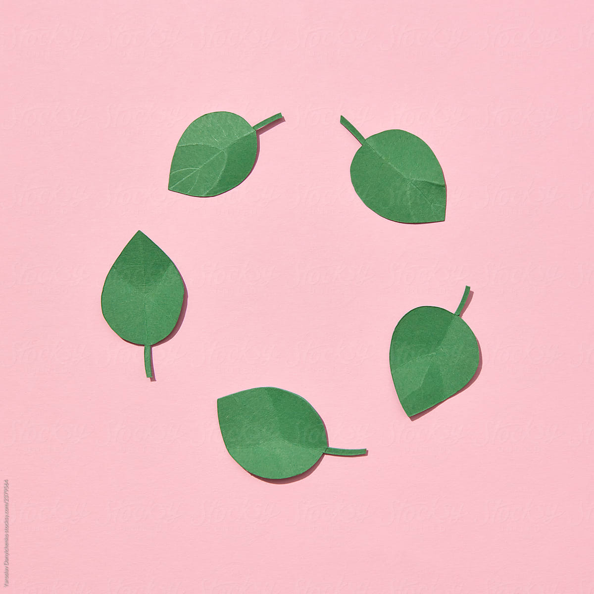 Paper green mint leaves on pink background