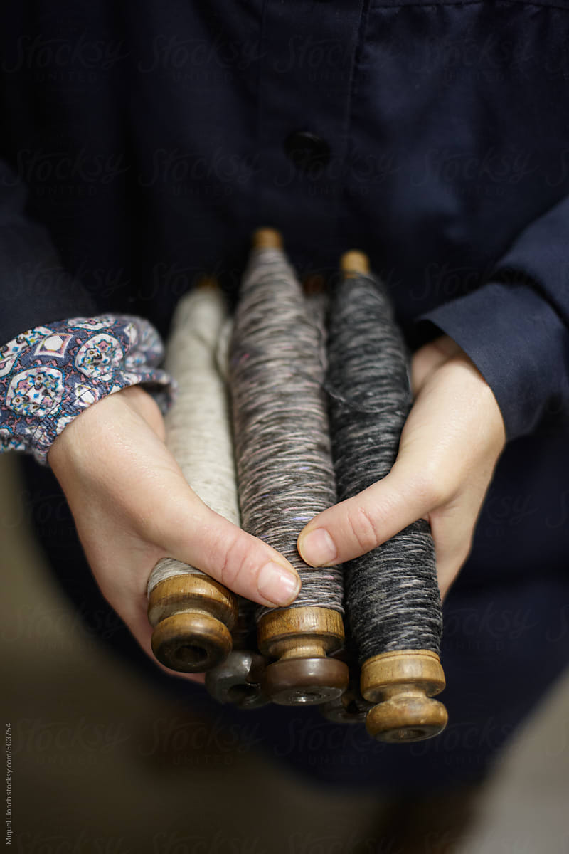 Close up of female hands holding  wool thread bobbins