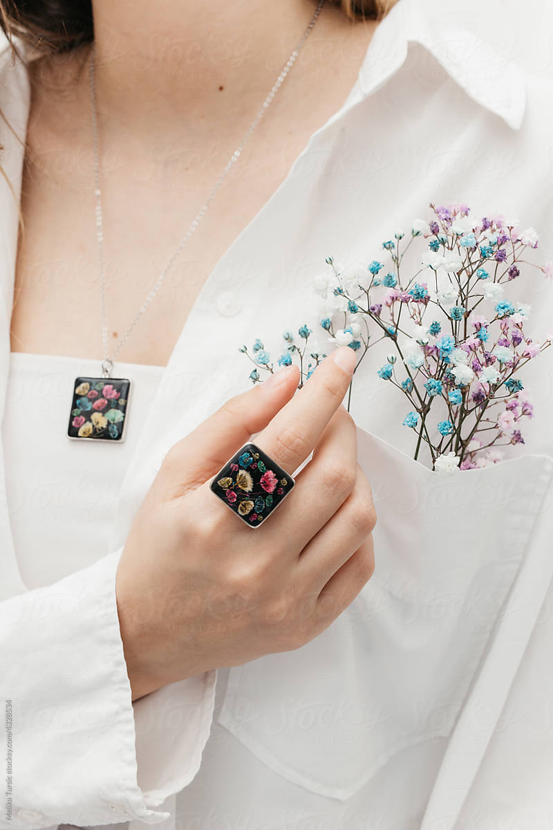woman wearing floral epoxy ring and necklace