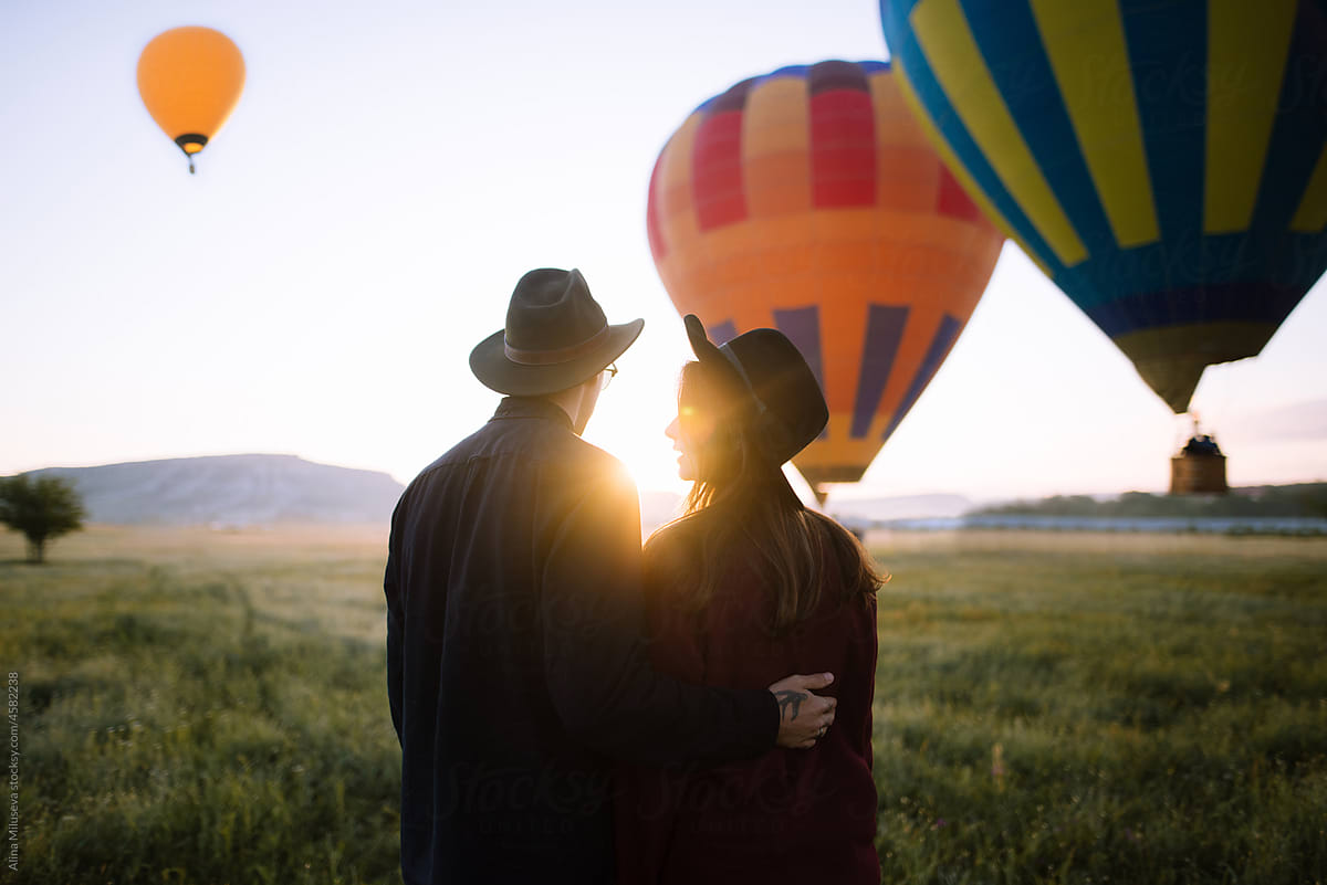 Young couple watching hot air balloons in the sky