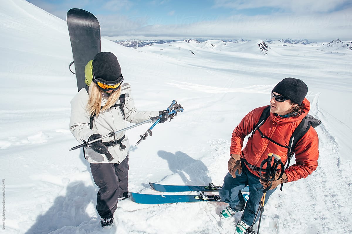 Skier and snowboarder on climbing adventure