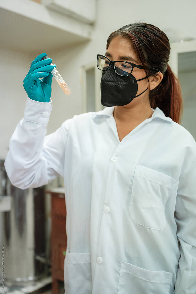 Female biologist analyzing sample in test tube