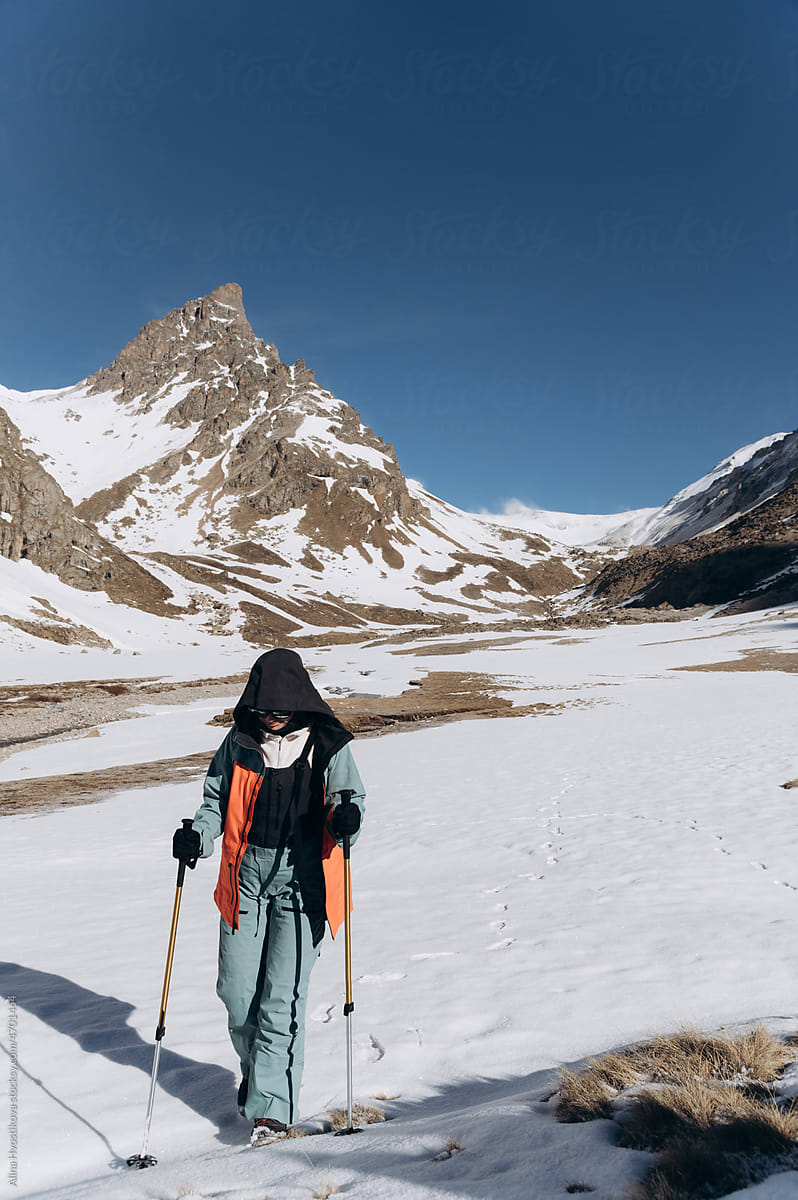 Unrecognizable traveler walking against snowy mountains