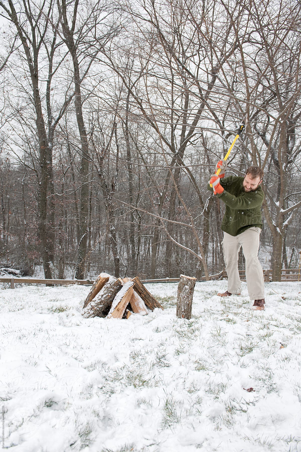 Splitting Firewood: Man Chops Wood For Fire As Snow Falls