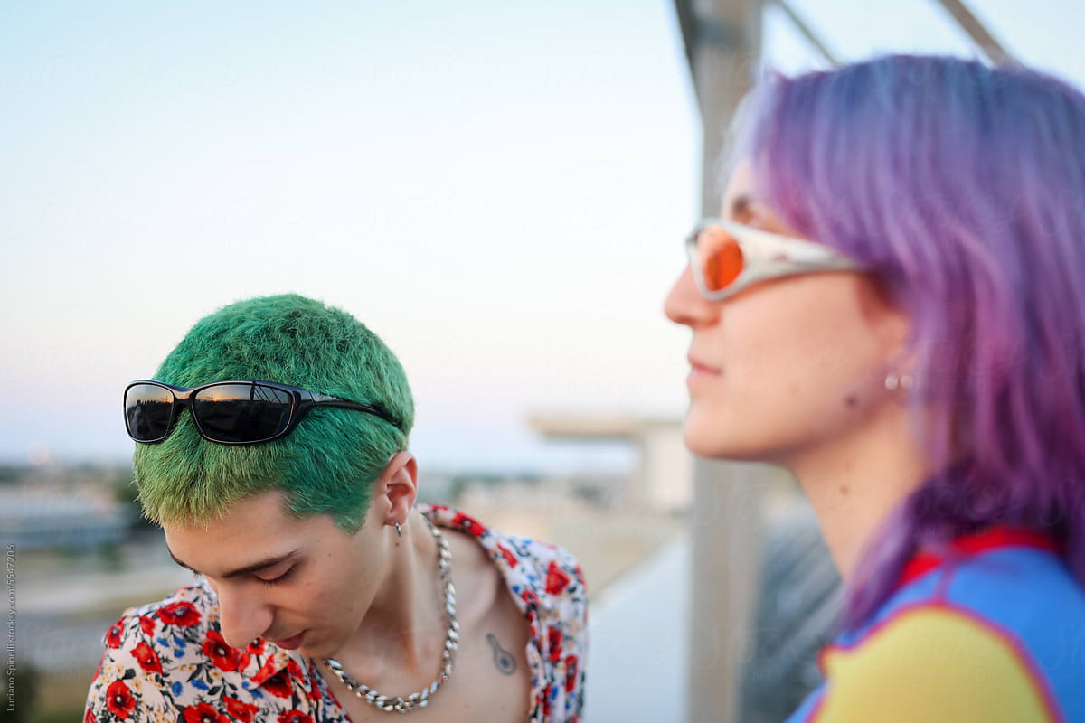 Generation Z couple with purple and green hair wearing sunglasses