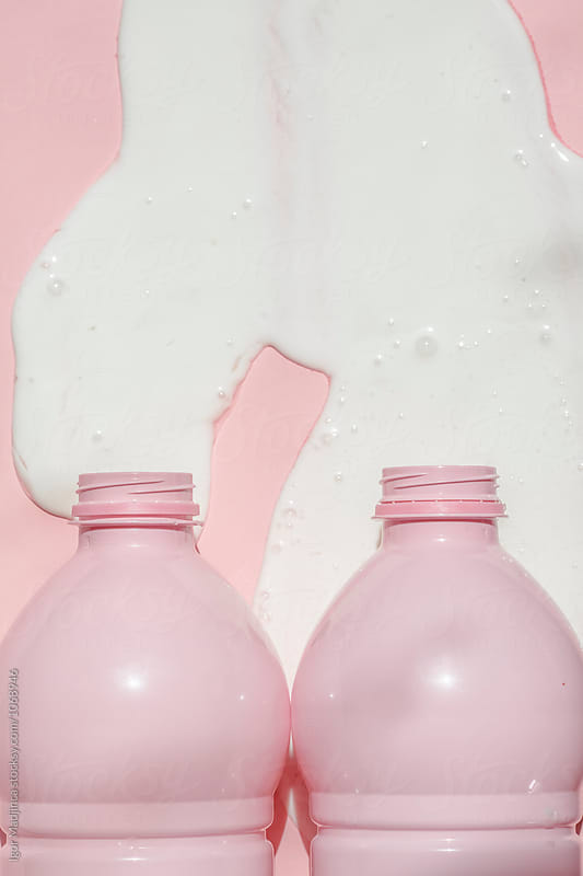 food, milk, two, spilled milk from two pink bottles on pink background