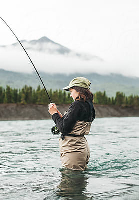 Fisherwoman Smiling While Holding A Fishing Pole In The Kenai River by  Stocksy Contributor Sophia Juliette - Stocksy