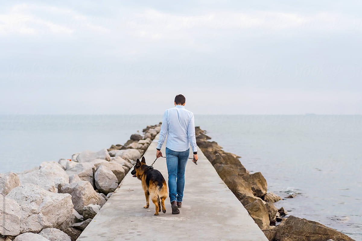 Man walking in a jetty with his dog