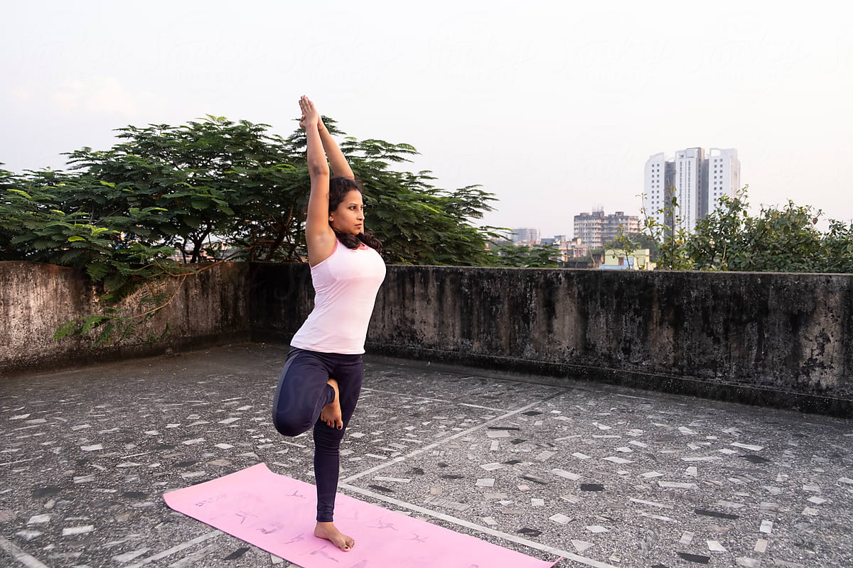 Active Woman Doing Yoga Poses At Roof Of A Urban City by Stocksy