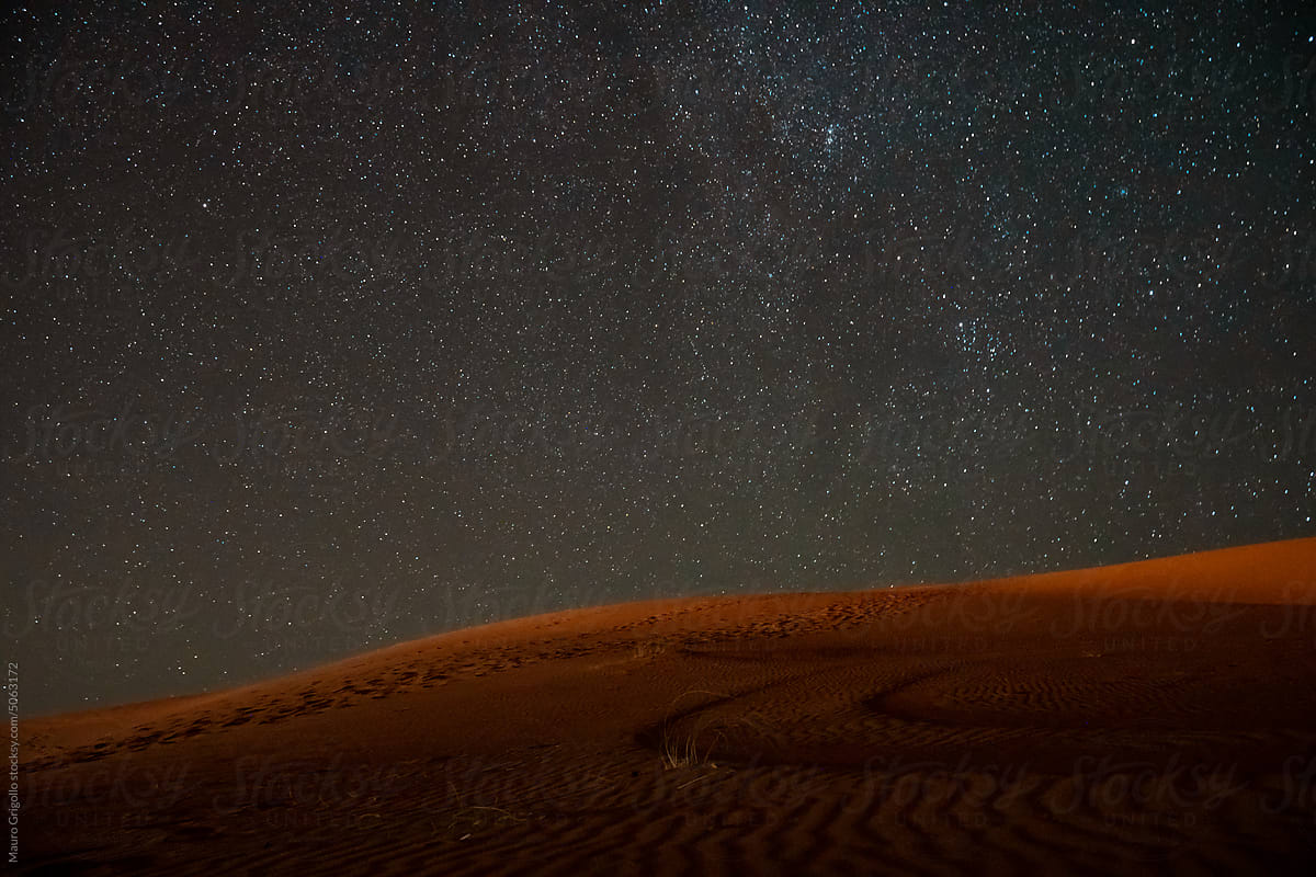 Desert dunes at night with stars in the sky
