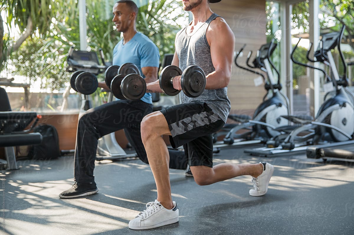 Man exercising at the gym with private coach