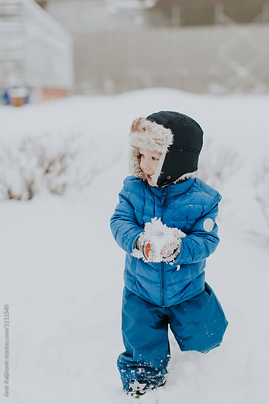 Cute little boy playing in winter snow
