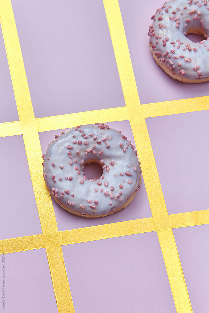 Donuts lying in golden grid of tic-tac-toe game