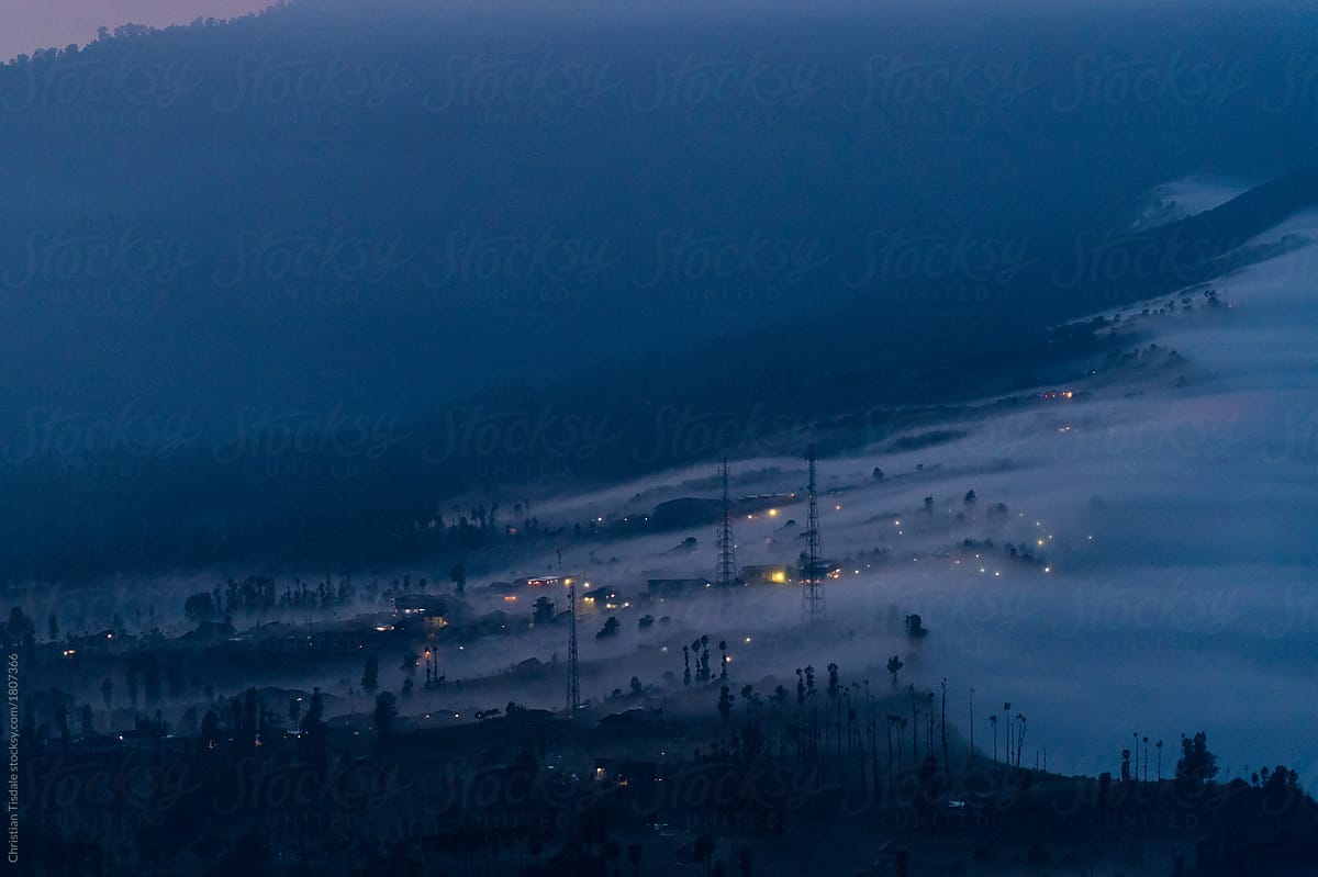 Fog blowing into a village before dawn