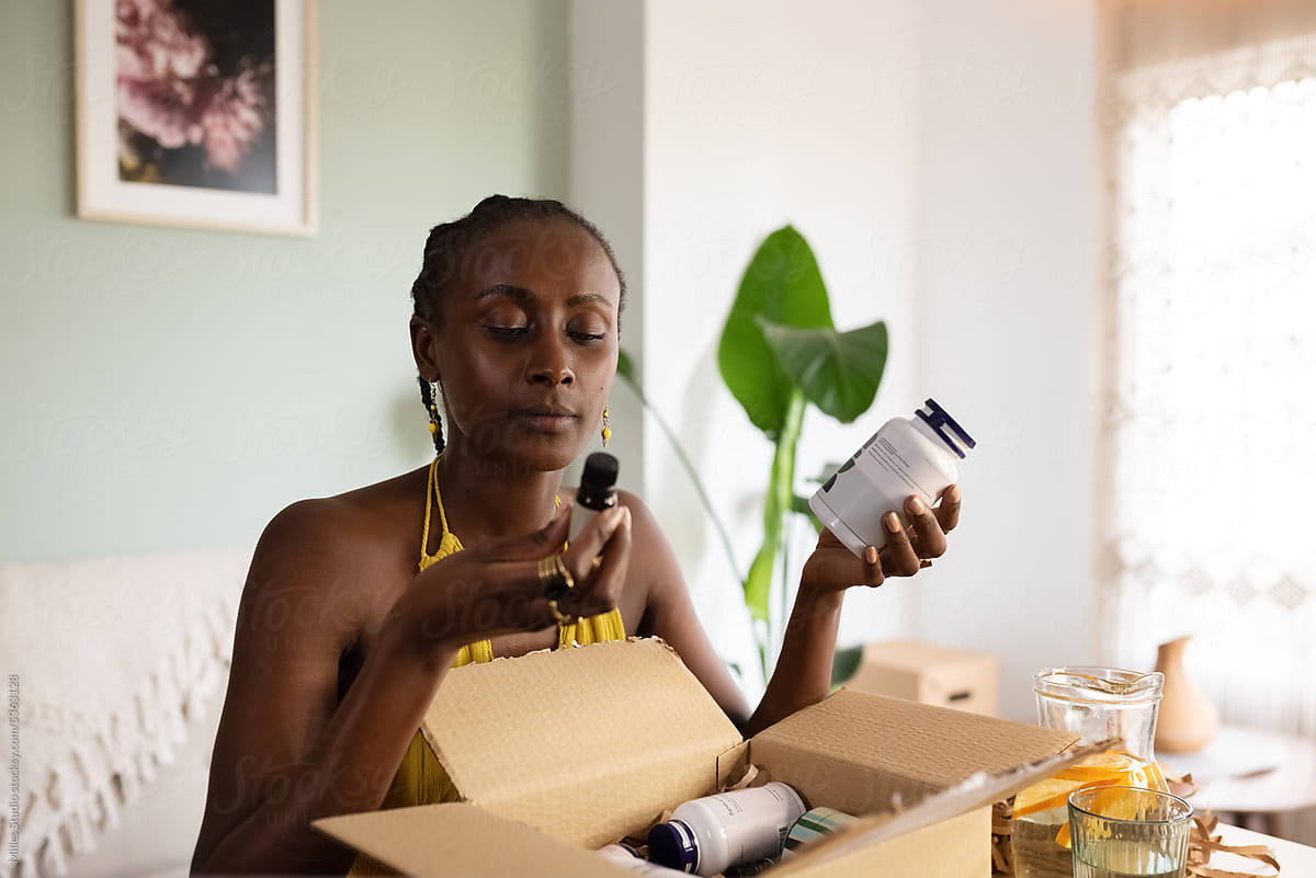 Black woman reading label on essential oil