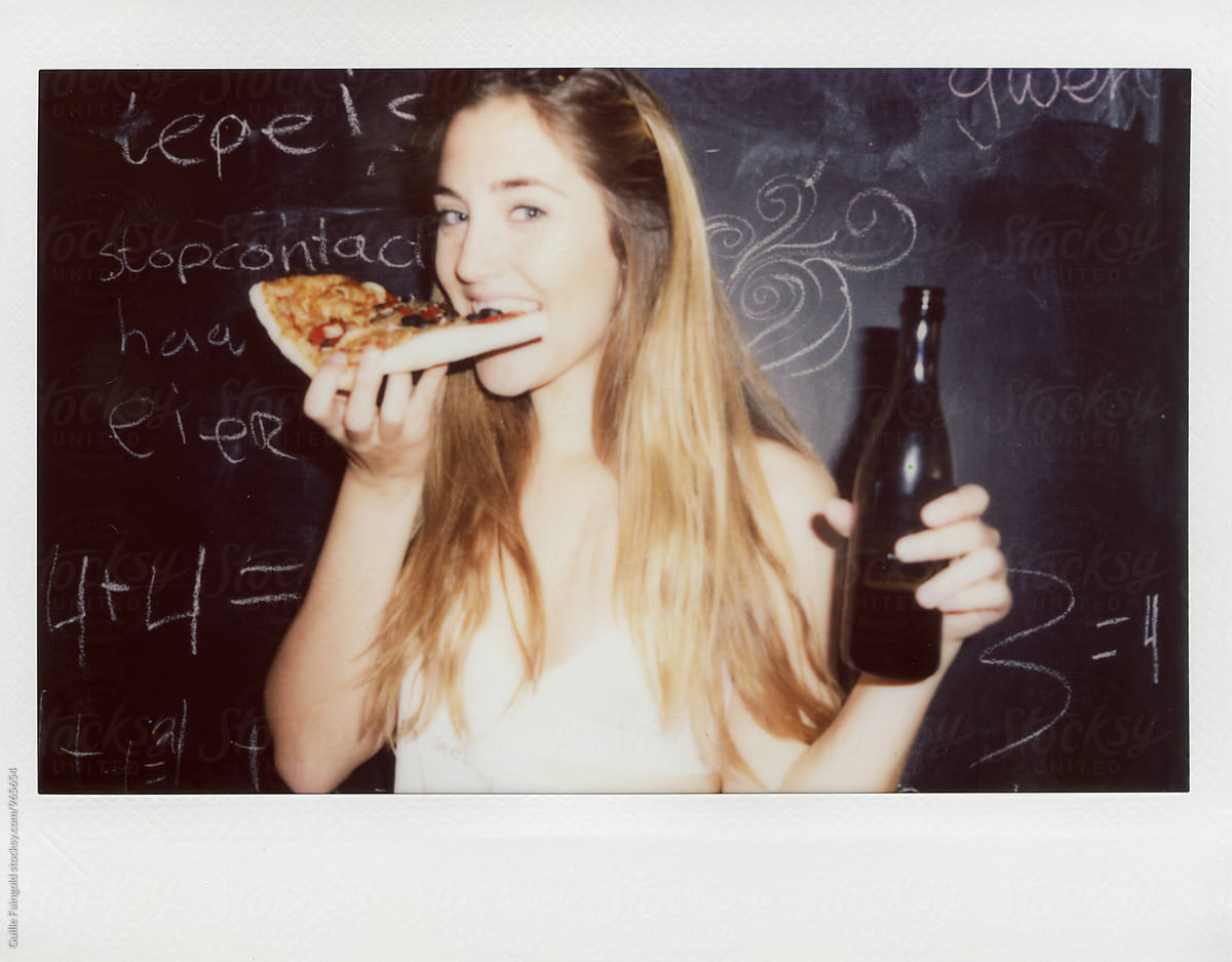 girl looking at camera while biting pizza